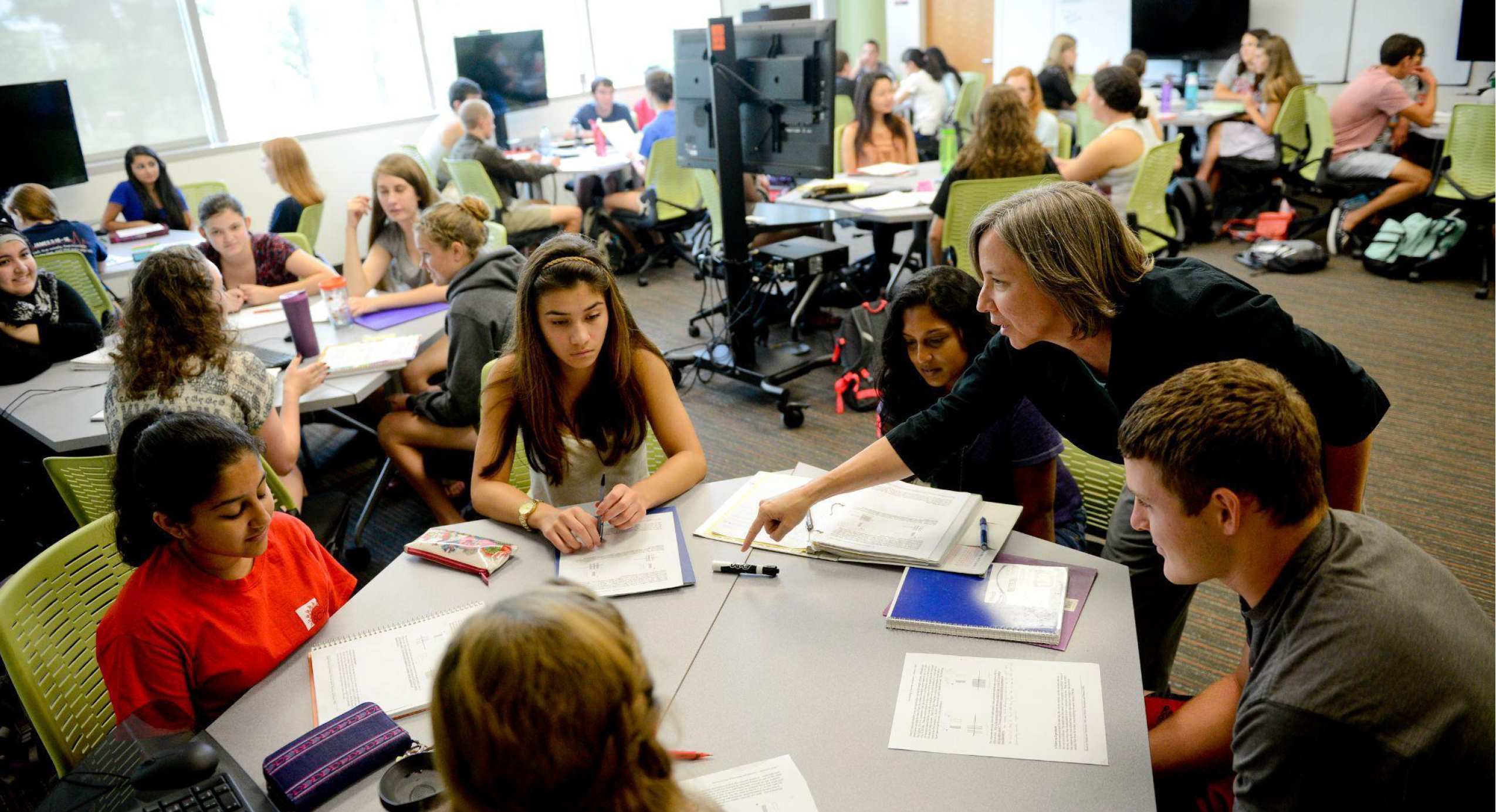 Photo of teacher assisting students